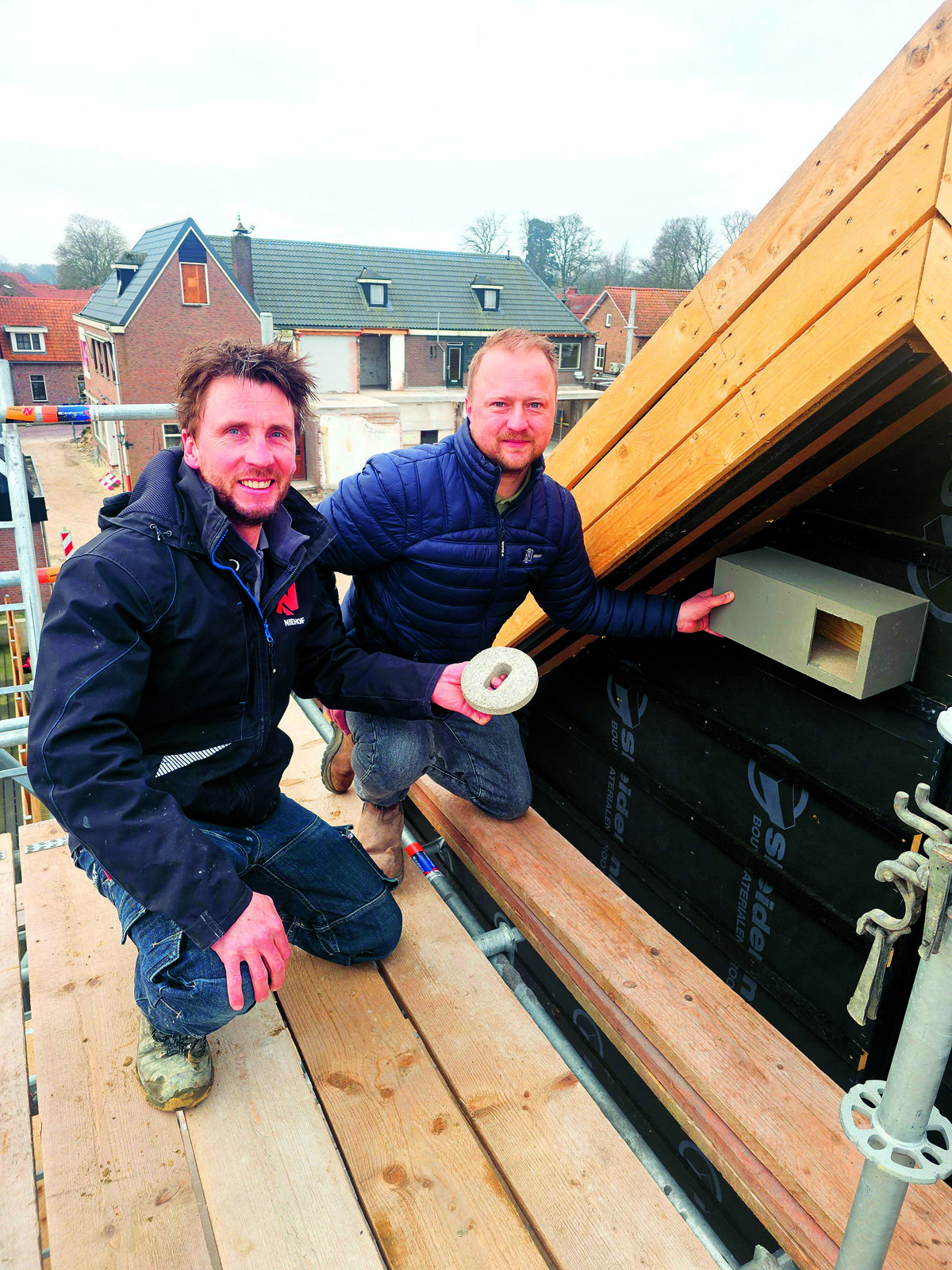 Harm Bossink en Stef Kleinhaarhuis van Aannemersbedrijf Niehof plaatsen de eerste gierzwaluwkst in de oostgevel van appartementencomplex Bosch Hook van de familie Oude Brunink.jpg
