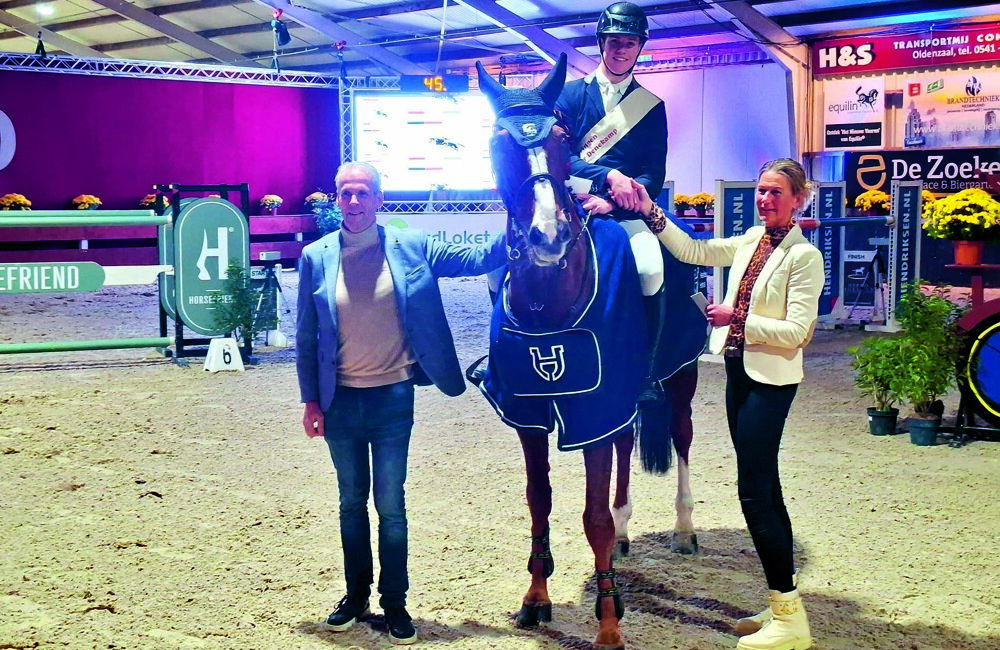 Lars Schroder wordt gefeliciteerd door jurylid Janet Vlierman-Koekkoek en voorzitter Frank Nieuwhuis met zijn overwinning in het mastersspringen